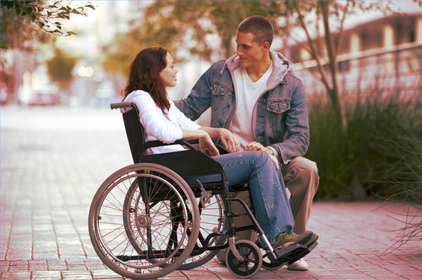 mujer en silla de ruedas y su pareja al lado